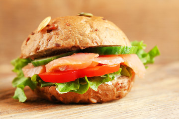 Sandwich with salmon on wooden background