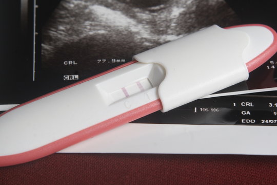 Pregnancy Test Pack At Dark Red Background
