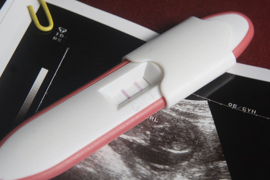 Pregnancy Test Pack At Dark Red Background