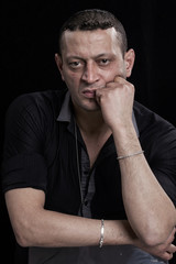 Frowning man portrait looking at camera on black background