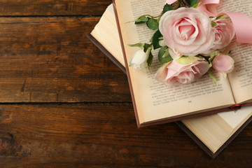 Obraz premium Books with flowers on wooden background