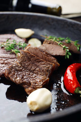 Steak in frying pan on table close up
