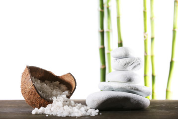 Still life of spa stones and coconut shell of sea salt