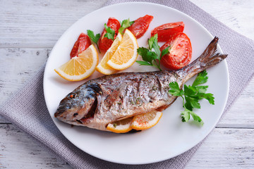 Tasty baked fish on table close-up
