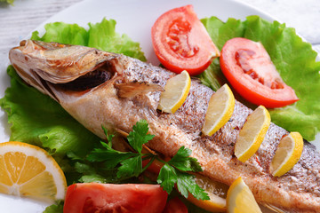 Tasty baked fish on table close-up