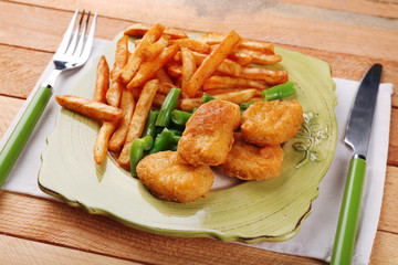 Breaded fried chicken nuggets and potatoes with asparagus