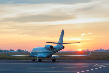 Fototapeta na wymiar Business jet on the apron of aircraft. Dawn at airport