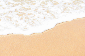Fototapeta na wymiar wave breaking into foam on the sand beach