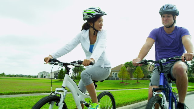 Healthy Young Ethnic Couple Cycling Together