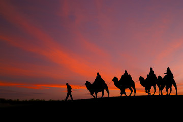 great sky and caravan travelers riding camels - 77041130