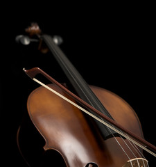 Cello and its bow set against a black background.