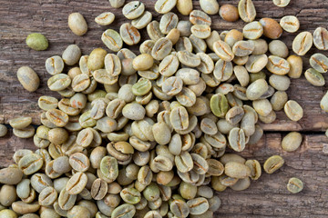 green coffee beans on wooden surface
