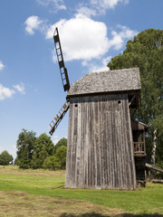 Old wooden windmill on background of blue sky © wjarek