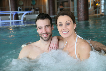 Couple enjoying bath in spa center jacuzzi