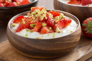 sweet yogurt with fresh strawberries and pistachios in a bowl
