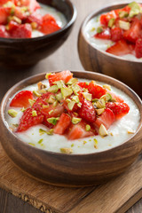 sweet yogurt with fresh strawberries and pistachios in a bowls