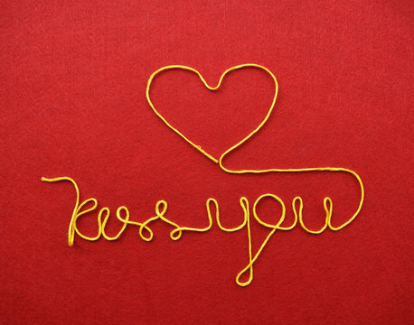 kiss you ribbon greeting and hearts on red background
