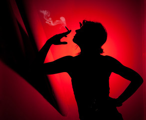 Silueta de mujer fumando sobre fondo rojo.
