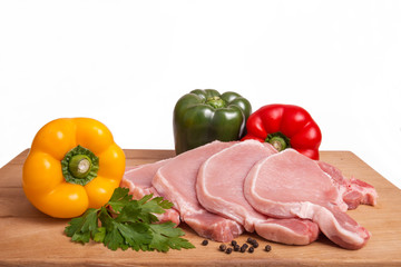 Raw pork meat, vegetables and spices, arranged on kitchen board
