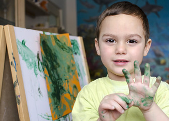 Portrait of a child boy  painting a colorful abstract picture.