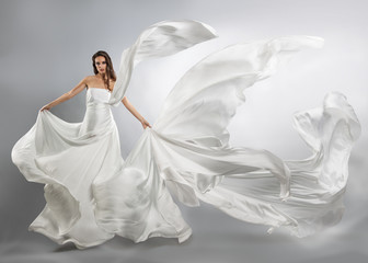 beautiful young girl in flying white dress. Flowing fabric