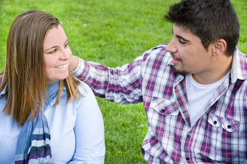 Fototapeta premium Young man and young woman smiling in park