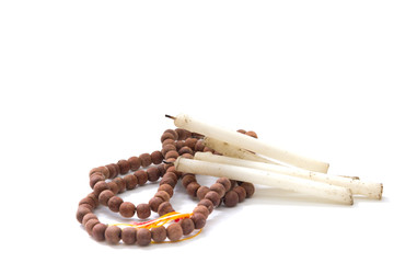 Rosary and candle isolated on white background
