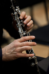Human hands playing a clarinet closeup - obrazy, fototapety, plakaty