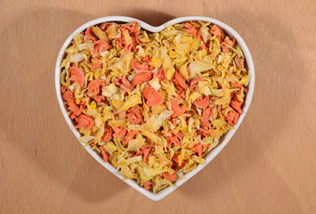 Dried carrots and onions in plate in form of heart