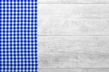 Picnic dinner table with checkered tablecloth wooden background