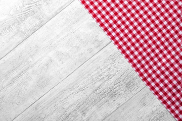 Wooden picnic dinner table with red white checkered tablecloth