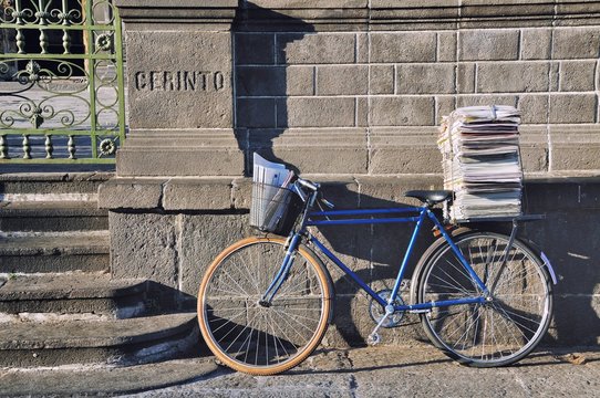 Fototapeta Postman Bike with a bunch of papers leaned against the wall
