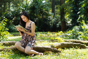 Girl with digital tablet in the forest