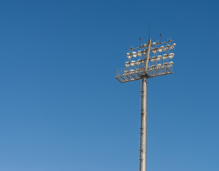 The Stadium spot-light tower over blue sky background.