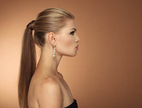 Portrait of fashionable woman with long hair tail in profile