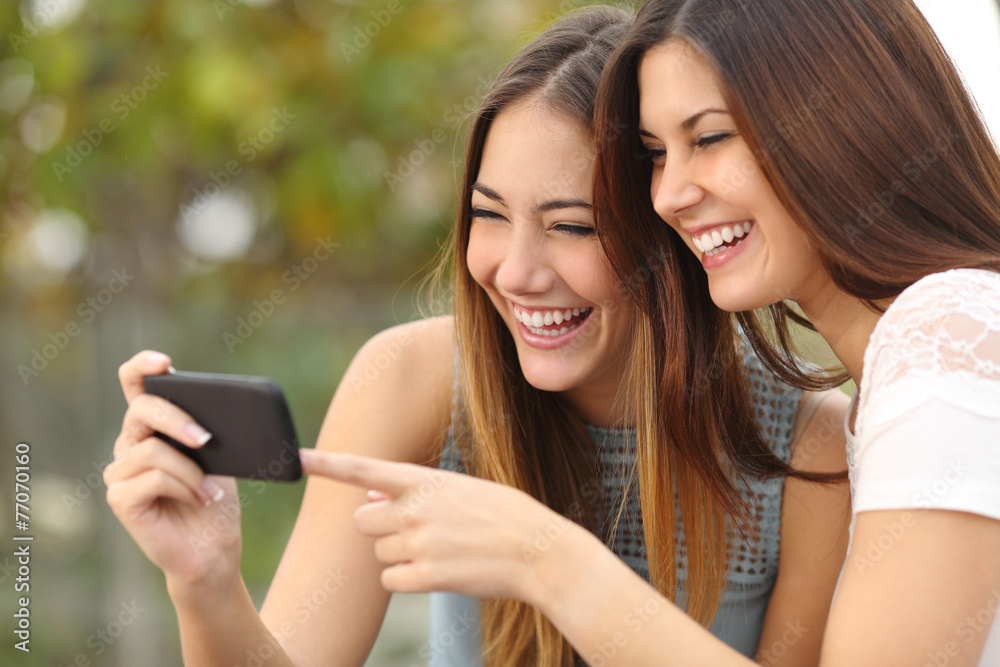 Sticker Women friends laughing and sharing media in a smart phone