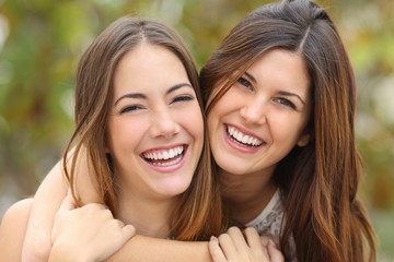 Two women friends laughing with a perfect white teeth