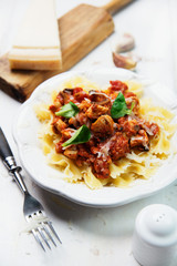 Farfalle pasta with chicken, tomato sauce and mushrooms