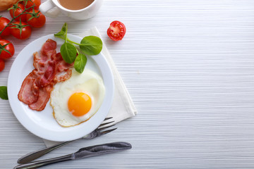 Bacon and eggs on color wooden table background