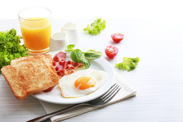 Bacon and eggs on color wooden table and white background
