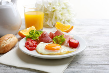 Bacon and eggs on wooden table and white background