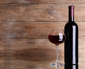 Red wine on table on wooden background