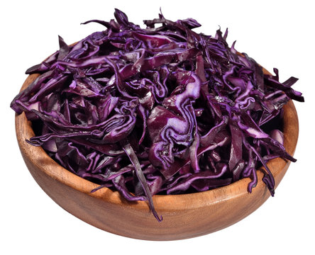 Sliced red cabbage in a wooden bowl on a white