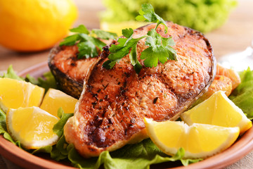 Tasty baked fish on plate on table close-up