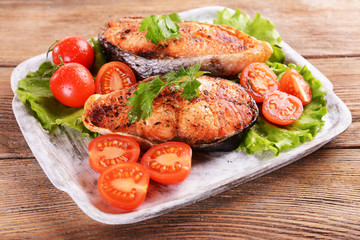 Tasty baked fish on plate on table close-up