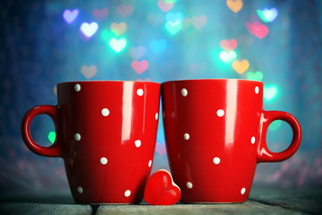 Two red cups on table on lights background