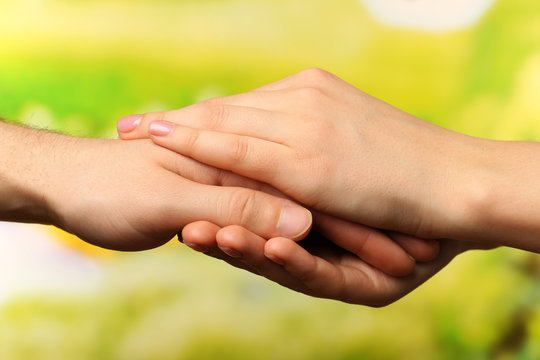 Male and female hands on bright background