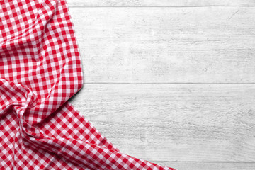 Red checkered tablecloth on white wooden table background - 77073969