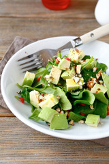 Salad with slices of avocado and spinach in a bowl