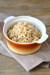 Boiled pearl barley in brown ceramic pot